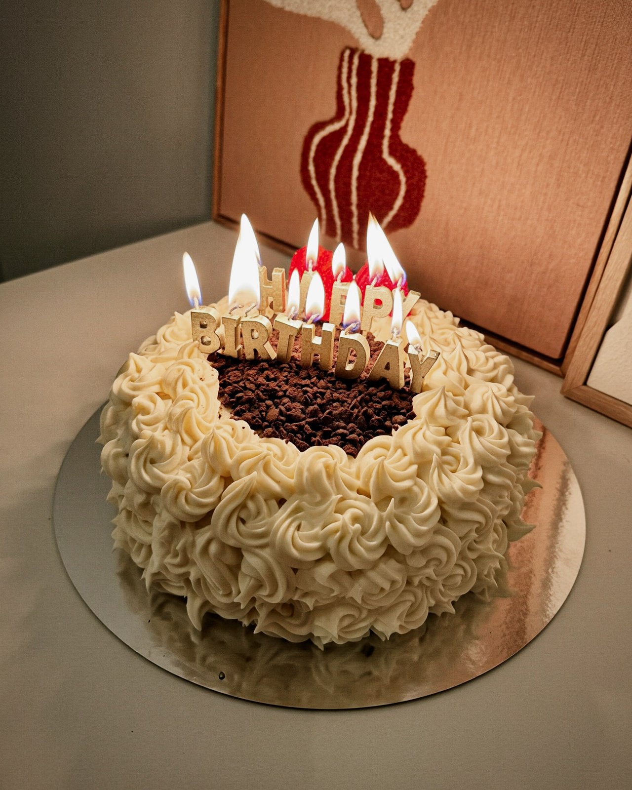 Chocolate birthday cake with cream rosettes and candles